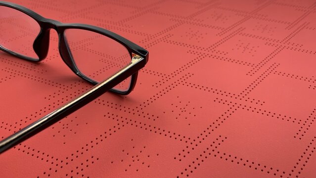 Stylish black framed glasses on vibrant coral background, photo concept