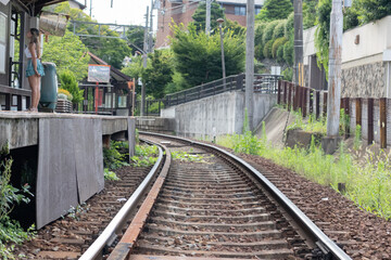 Fototapeta premium Young Woman Reading Map Beside Empty Railway
