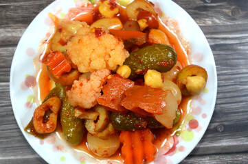 plate of Arabian pickles, marinated preserved pickled vegetables of chili peppers, cucumber, turnip, carrot, olive, cauliflower, Arabic traditional Egyptian appetizers as a side dish with a main dish