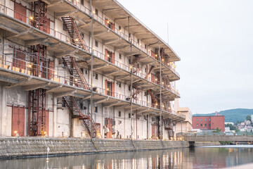 Old industrial warehouse building with fire escapes by waterfront in urban area at Hokkaido, Japan