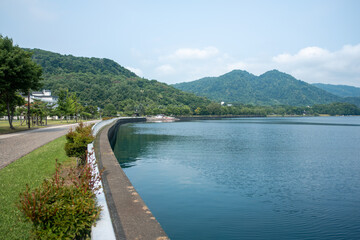 Scenic lakeside walkway with mountains and greenery on a clear day at Lake Toya, Abuta, Hokkaido, Japan