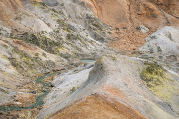 Geothermal hot spring flowing through colorful volcanic landscape in Iceland at Noboribetsu Jigokudani Valley, Noboribetsu, Hokkaido, Japan