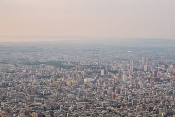 Panoramic view from Moiwa mountain, Aerial view of dense urban cityscape with buildings and skyline at sunset at Sapporo, Hokkaido, Japan