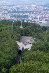 Panoramic view from Moiwa mountain, Train entering tunnel in forested mountain area overlooking cityscape at Sapporo, Hokkaido, Japan