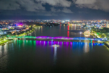 Fototapeta premium Panoramic view of Truong Tien Bridge in Hue City at night. Bridge illuminated all over with blurry reflection on. Travel and landscape concept