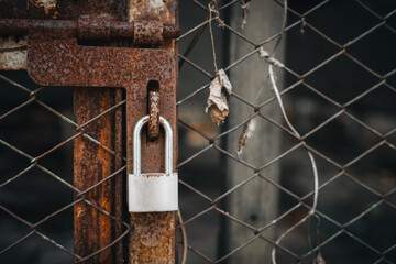 Old Rusty Metal Lock on a Wire Fence Security Concept