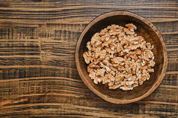 Healthy walnut snack in a wooden bowl on a rustic table