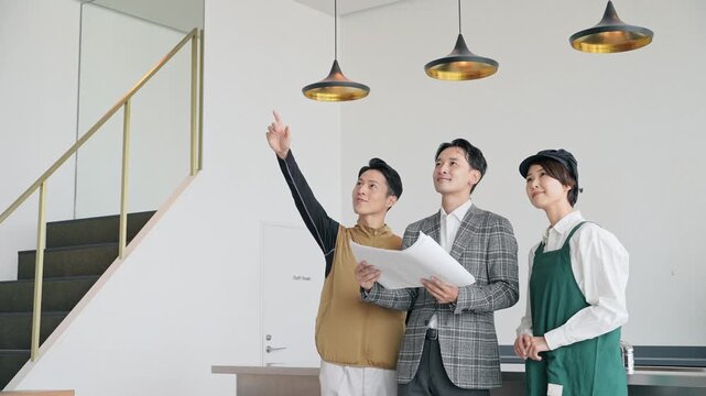 店舗施設で打ち合わせする店員・設計士・作業員