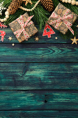 Festive flat lay with two wrapped gifts, pine branches, pinecones, red reindeer and tree cutouts on...