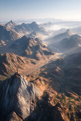 Fototapeta premium Aerial view of rugged mountain landscape with dramatic peaks and valleys, showcasing natural beauty and diverse terrain under soft morning light and misty atmosphere
