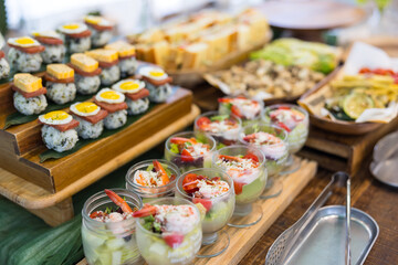 Fresh sushi and appetizer buffet on wooden table