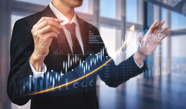 A business professional in a modern office uses augmented reality graphics to analyze financial data and trends, highlighting growth and strategic insights in investment. Scalp - Powered by Adobe
