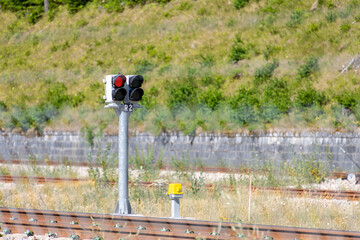 Railway traffic light on a pole. The red lights are on