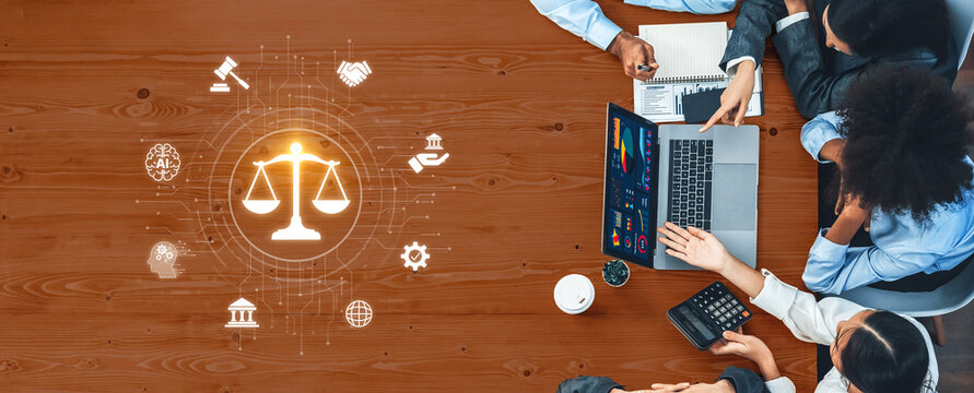 A business meeting features professionals analyzing legal concepts using a laptop and discussing finance. Icons of justice and charts surround them on a wooden table. Trope - Powered by Adobe