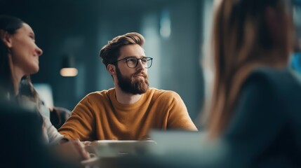 Engaged bearded man in glasses attends business meeting, deep in thought or actively listening, reflecting professional focus and collaborative discussion. Business concept.