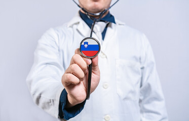 Doctor holding stethoscope with Slovenian flag. Slovenia health and care concept