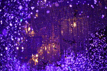 無数のクリスタルと紫色のLEDイルミネーションの光が輝き反射し合う幻想的で豪華な光のトンネルの抽象的な背景