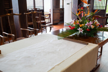 A Chinese-style study room with rice paper spread on a solid wood table