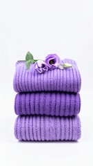 Stack of Purple Towels with Floral Decoration on White Background.