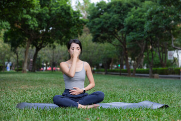 Woman practicing pranayama breathing exercise at park