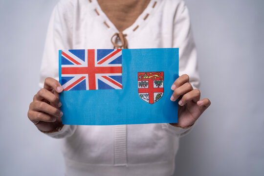 A person holding the flag of Fiji with pride, symbolizing patriotism, unity, and national identity. The image reflects love for the island nation and appreciation for Fijian culture and heritage