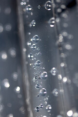 Close up of abstract floating bubbles water droplets condensation rain on a glass transparent bokeh background