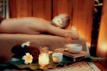 Woman customer having exfoliation treatment in luxury spa salon with warmth candle light ambient. Salt scrub beauty treatment in Health spa body scrub. Quiescent