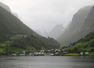 Village with Colorful Buildings, Trees and Foggy Mountains around it in Gudvangen, Norway 