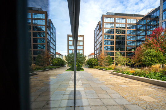 Modern office district in the city center. New glass high-rise buildings with a pedestrian walkway and a small park with trees in the business center.