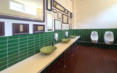 Public restroom interior with green tiles and mirrors