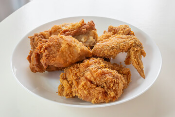 Crispy fried chicken in white plate on wood table