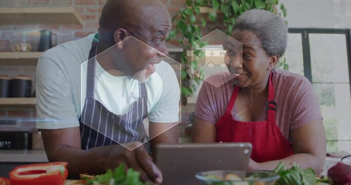 Chopping vegetables apron-clad couple preparing salad on home kitchen counter with tablet - Powered by Adobe