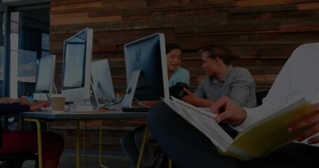 Reading yellow binder male wearing white shirt in office, with monitors, coffee cup, copy space