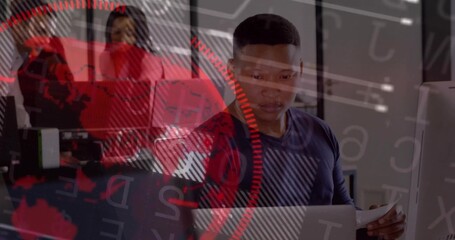 Reviewing African American man examining computer data while reading paper in office, with overlay
