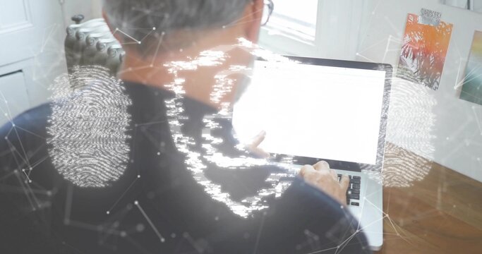 Typing middle-aged man in dark sweater, glasses on laptop in home office, with security overlay - Powered by Adobe