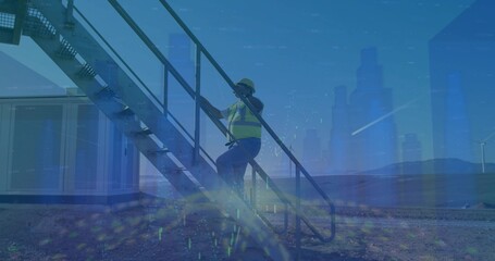 Fototapeta premium Ascending maintenance technician climbing staircase at wind farm, with safety vest and helmet