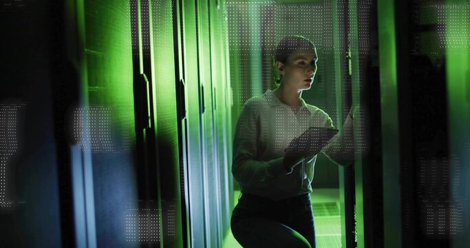 IT technician inspecting server racks using tablet in data center, with green LEDs and floor tiles
