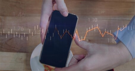 Holding smartphone, hands wearing blue shirt showing financial chart in cafe, with cup and saucer