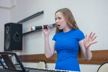 Caucasian woman singing into microphone. 