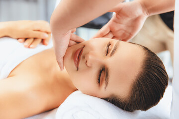 Obraz premium Closeup woman enjoying relaxing anti-stress head massage and pampering facial beauty skin recreation leisure in dayspa modern light ambient at luxury resort or hotel spa salon. Quiescent