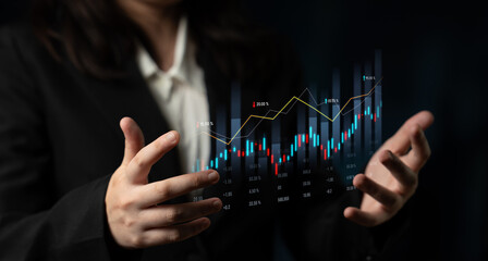 A business professional presents a digital financial chart with glowing lines, symbolizing the...