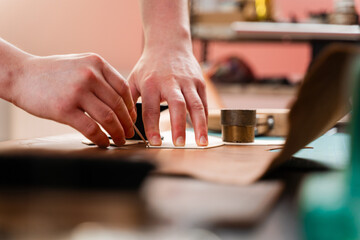 Leather Cutting with Pattern. Leather artisan uses templates to cut hides accurately. Leather crafting process showing precise cutting. Skilled artisan cuts leather with accuracy.