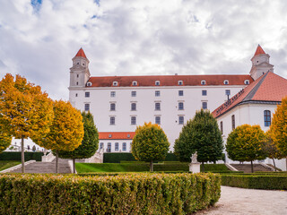 Bratislava Castle in Slovakia with trimmed linden trees (Tilia) and boxwood hedges in the baroque garden during autumn.