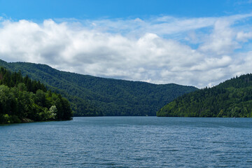 Obraz premium view of lake and hills with forest is beautiful, summer landscape on a bright and sunny day