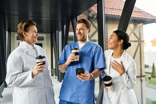 Multicultural healthcare team sharing a moment in a modern hospital corridor