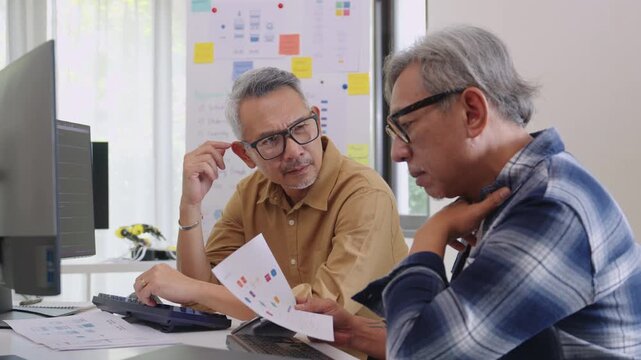 Group of asian senior in a collaborative software development analyzing  flowcharts  during a bootcamp training
