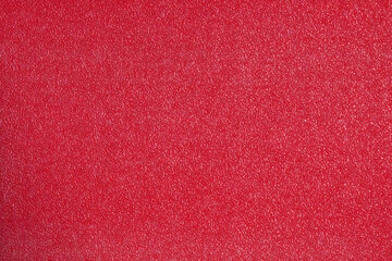 Fototapeta premium A vibrant, high-texture close-up of a synthetic sports court surface in an intense, bright red color, ideal for use as a dynamic abstract background or backdrop.