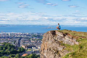 Person tourist gaze at stunning seascape and city from cliff