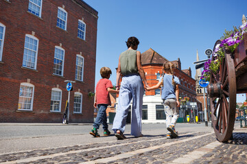 Kids and parent happily walking in the sun at countryside town