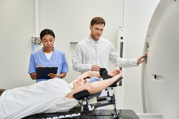 Obraz premium Healthcare team prepares patient for MRI scan in modern hospital setting
